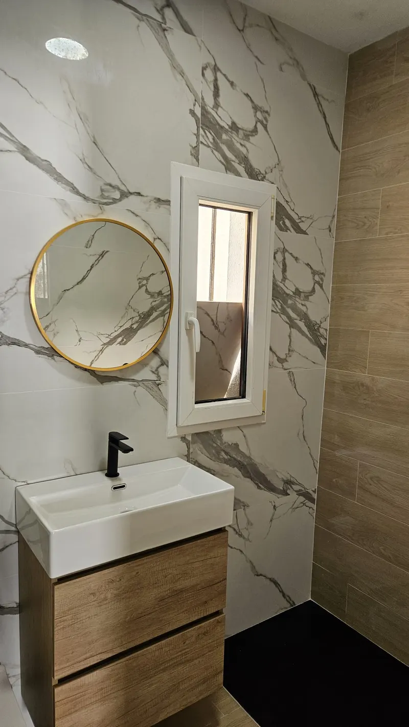 Baño con espejo redondo dorado