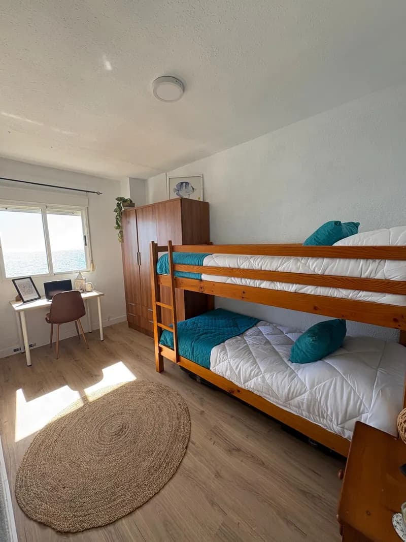 Habitación de literas con escritorio y vistas al mar