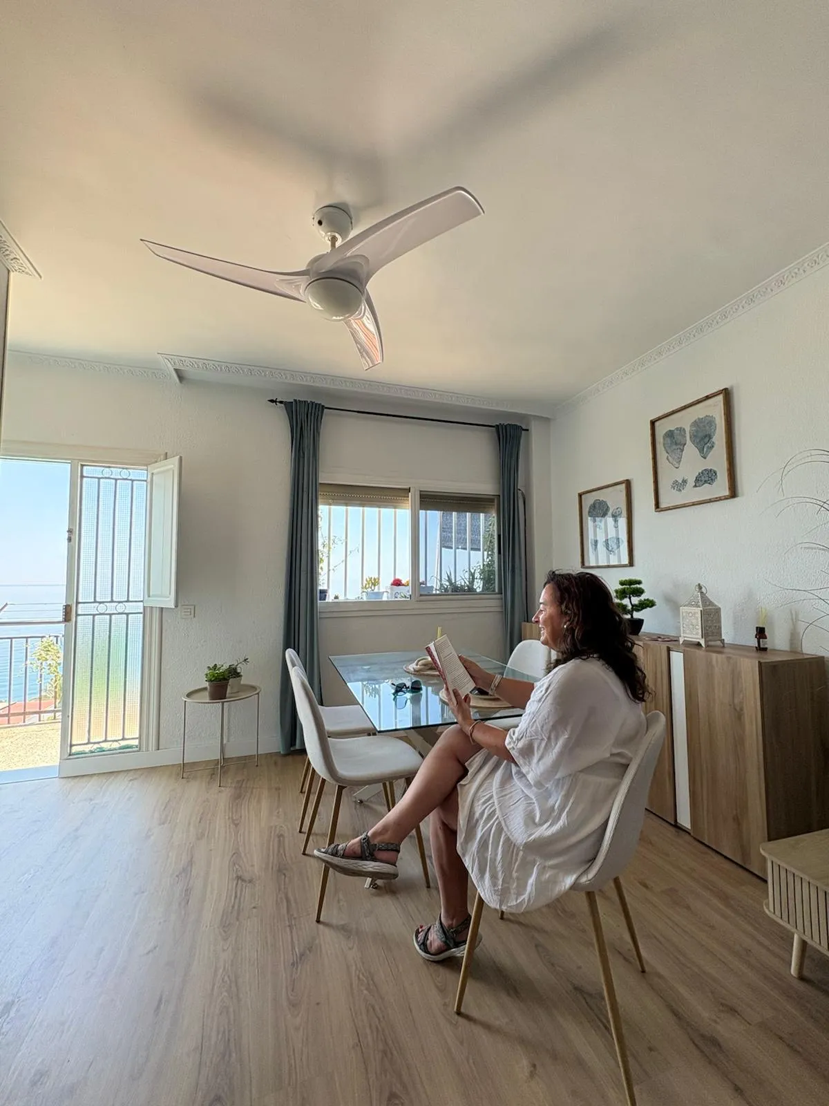 Eva leyendo en el salón de Ikigai Home, con el Mediterráneo tras la ventana